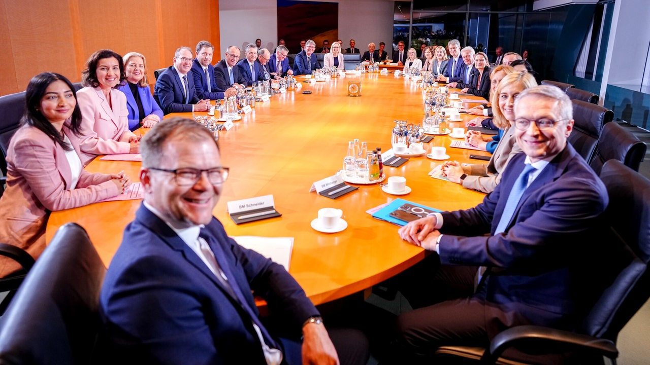 Das gesamte Bundeskabinett sitzt an einem Tisch.