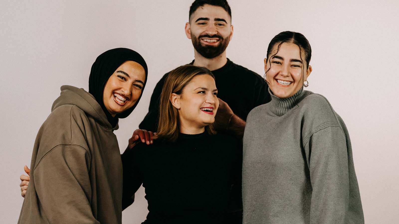 Vier junge Menschen posieren für ein Foto und lachen