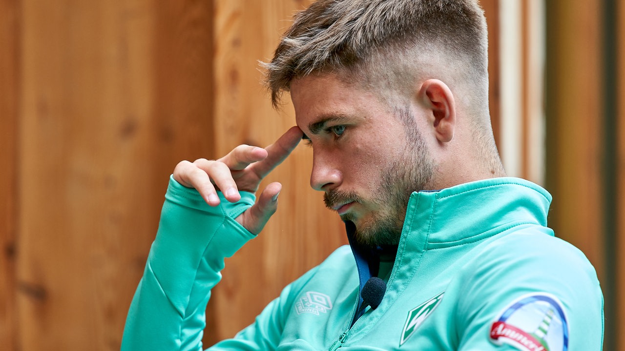 Werder-Spieler Romano Schmid im Profil, legt sich nachdenklich den Zeigefinger an den Kopf.