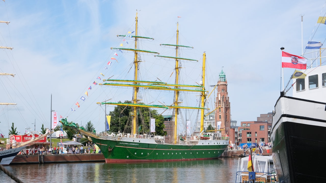 Ein grünes Segelschiff liegt im Hafen.